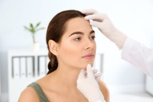 Dermatologist examines woman's face after Mohs surgery, verifying aesthetically appealing results
