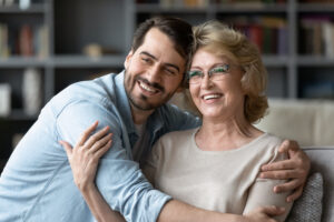 Son hugs his mother in her home after successful skin cancer treatment
