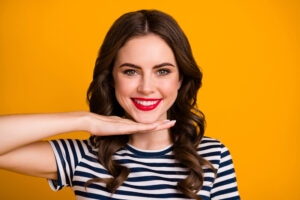 Quirky woman in her 30s is thrilled with her refreshed skin after cosmetic treatments.